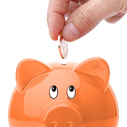 hand dropping a coin into a piggy bank